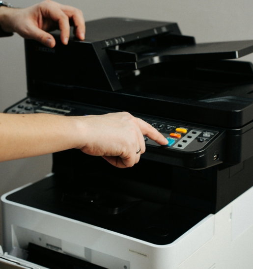 A person is pressing a button on a printer